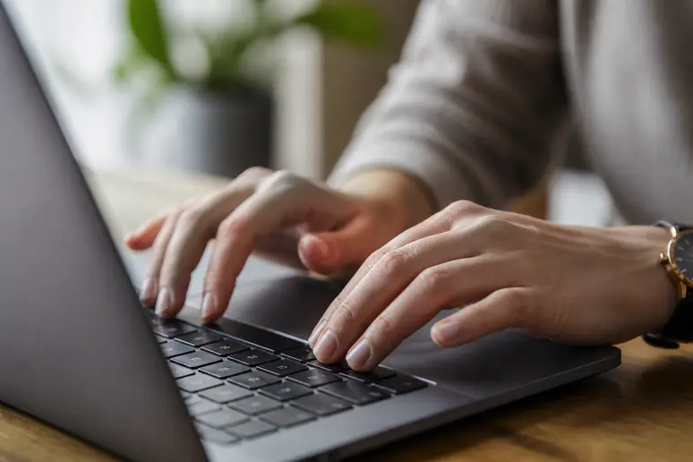 Mains tapant un code promotionnel dans un champ de saisie sur un clavier d'ordinateur.