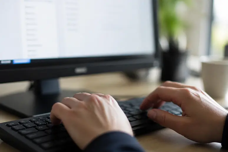 Mains d'un utilisateur tapant des mots-clés négatifs sur un clavier pour affiner le ciblage.