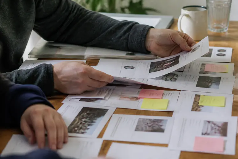 Mains triant des notes manuscrites pour un audit e-réputation et classant les mentions web