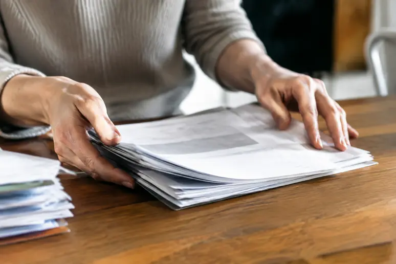 Mains triant des documents papier pour illustrer les limites du clean email gratuit