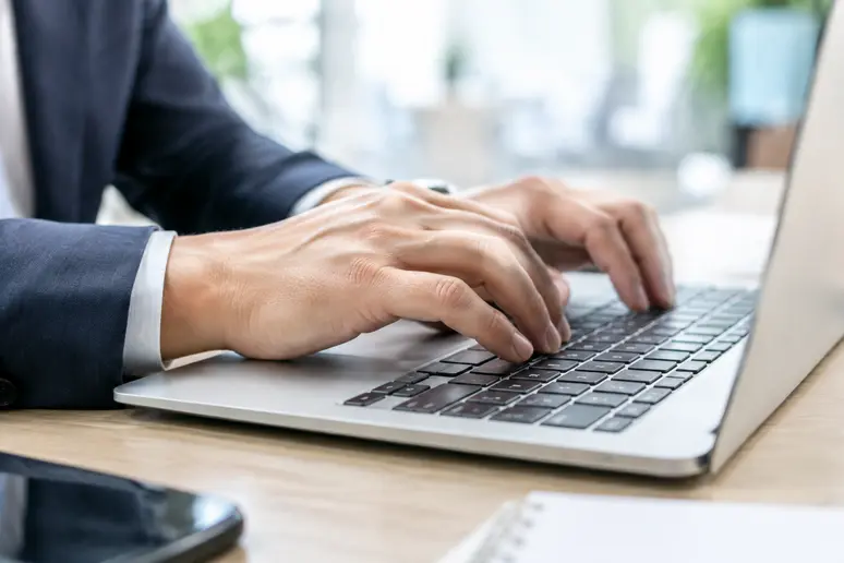 Mains d'un professionnel configurant les paramètres de sécurité d'une messagerie pour un email rgpd
