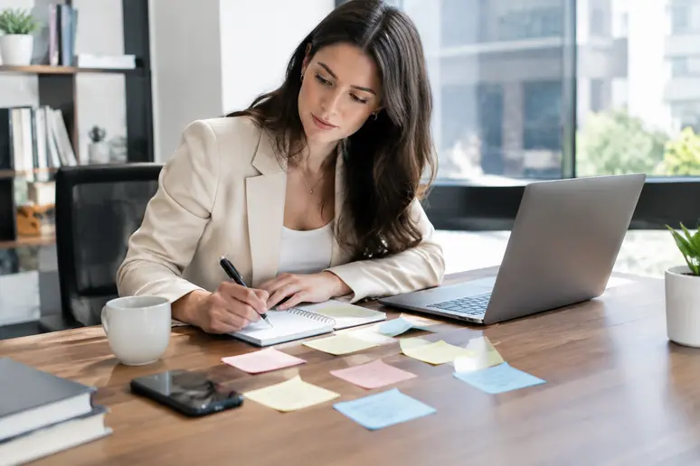 Professionnel préparant la structure d'un emailing exemple sur son bureau en bois