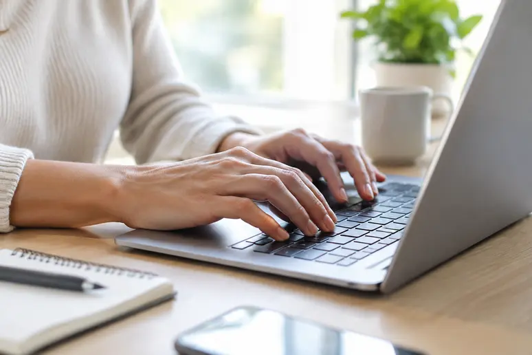 Mains rédigeant un emailing exemple de fidélisation client sur un clavier