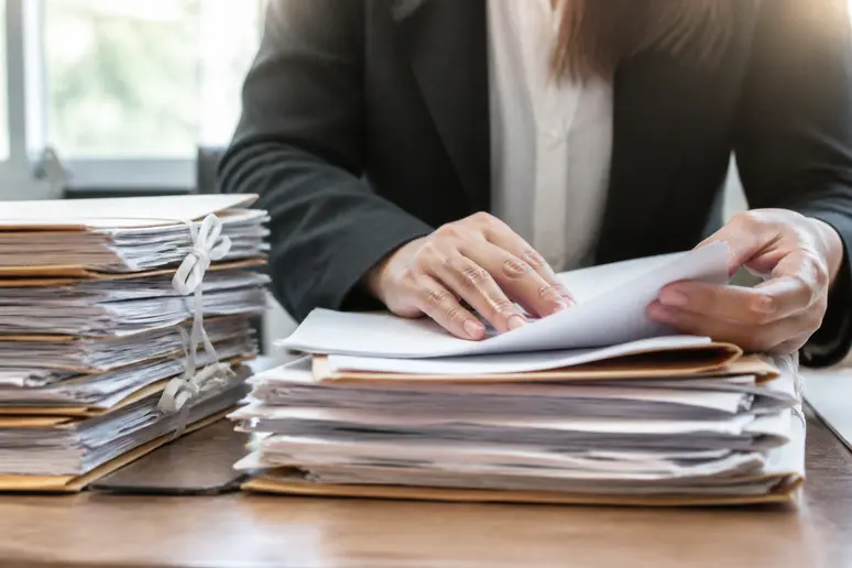 Classement de documents administratifs et dossiers professionnels sur un bureau en bois