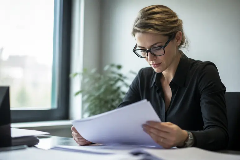 Professionnel consultant des documents administratifs sur son lieu de travail